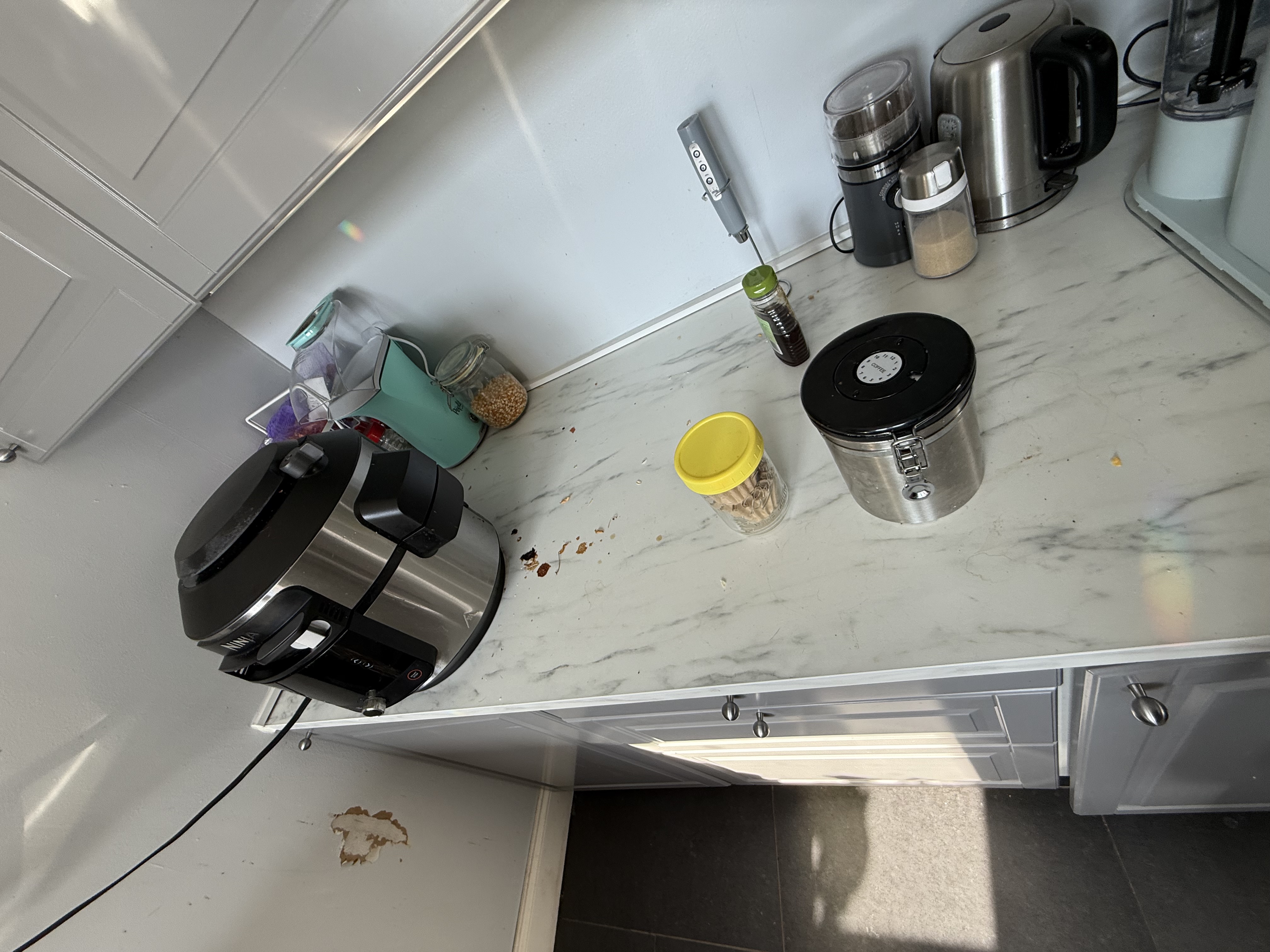 Marble kitchen counter with spills and crumbs before cleaning